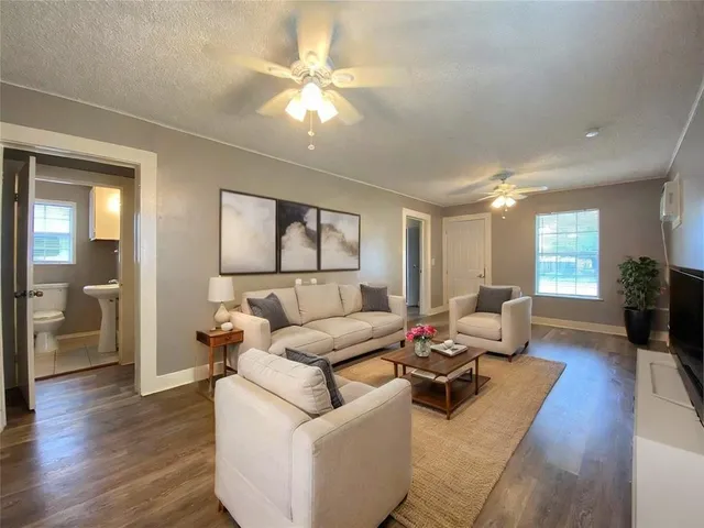 a living room with furniture and a wooden floor