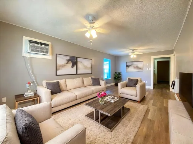 a living room with furniture and a wooden floor