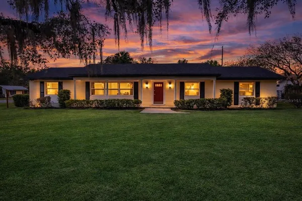 a front view of a house with a garden and yard