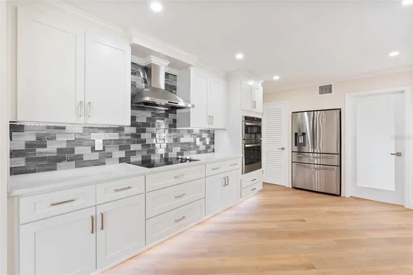 a kitchen with granite countertop white cabinets and stainless steel appliances