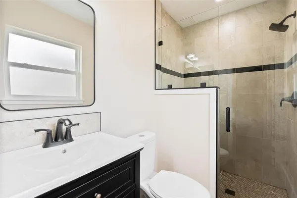 a bathroom with a sink vanity mirror and toilet