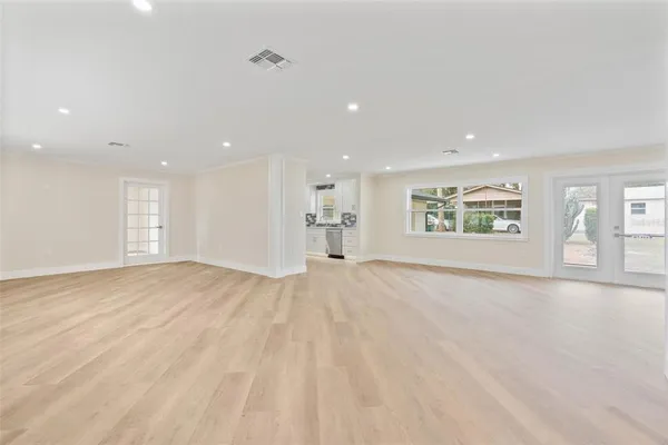 a view of an empty room with a window and chair