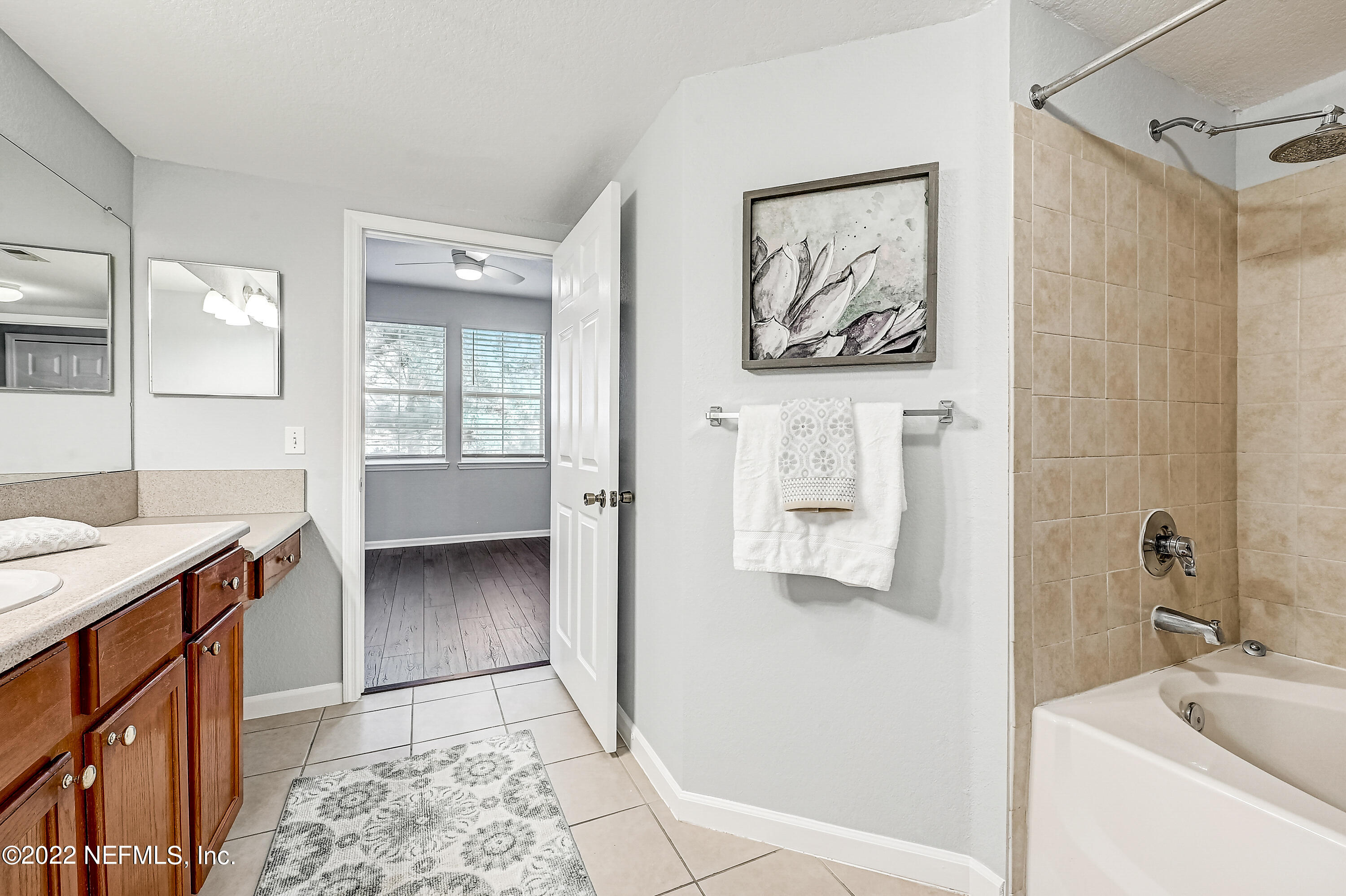 8550 Touchton Road, Unit 1132 Jacksonville, FL 32216 - Photo 16 of 43 a bathroom with a tub sink and mirror