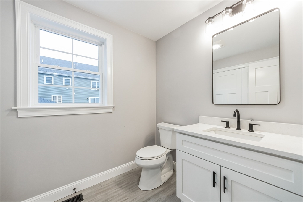 36 Gove Road Billerica, MA 01821 - Photo 13 of 30 a bathroom with a toilet a sink a mirror and a window