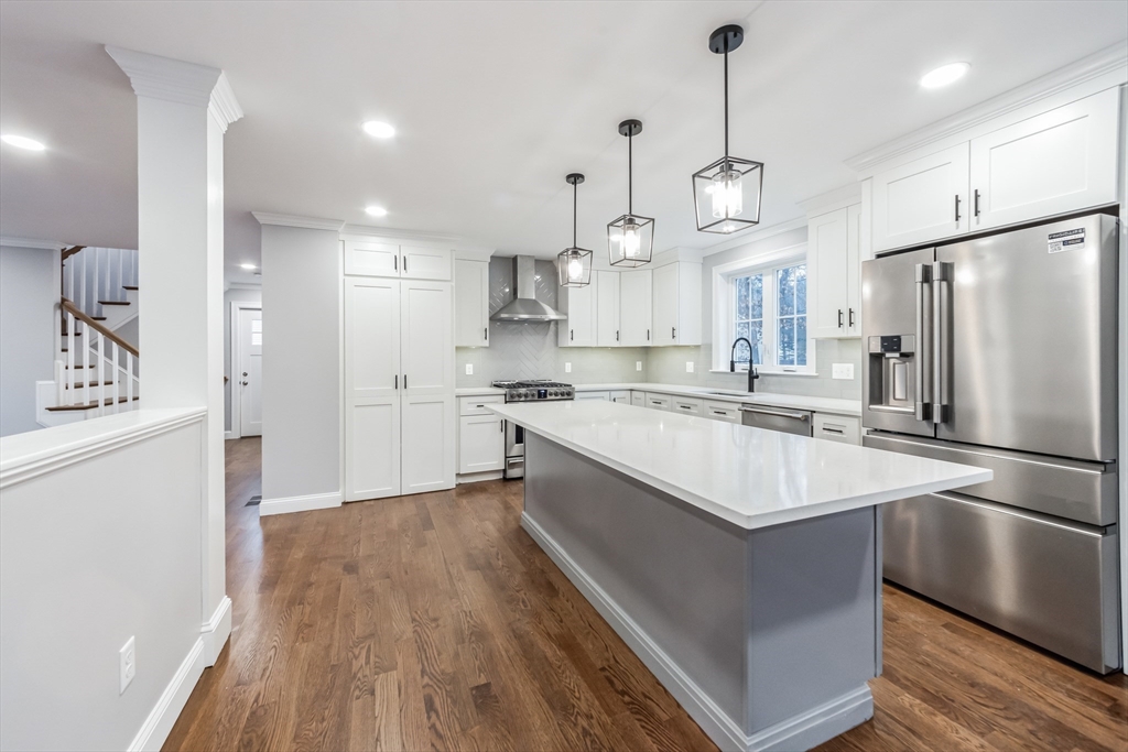 36 Gove Road Billerica, MA 01821 - Photo 6 of 30 a large kitchen with stainless steel appliances a refrigerator a sink dishwasher a oven and a dining table with wooden floor
