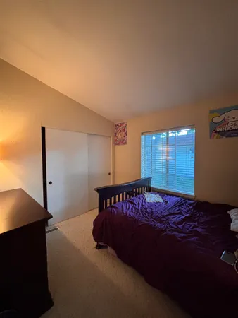 a bed sitting in a bedroom next to a window