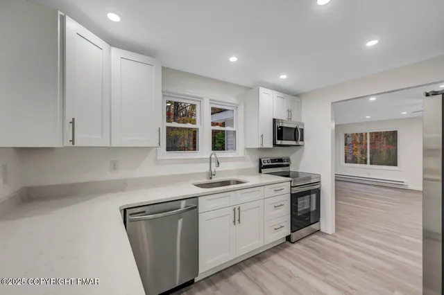 a kitchen with a sink stainless steel appliances and cabinets