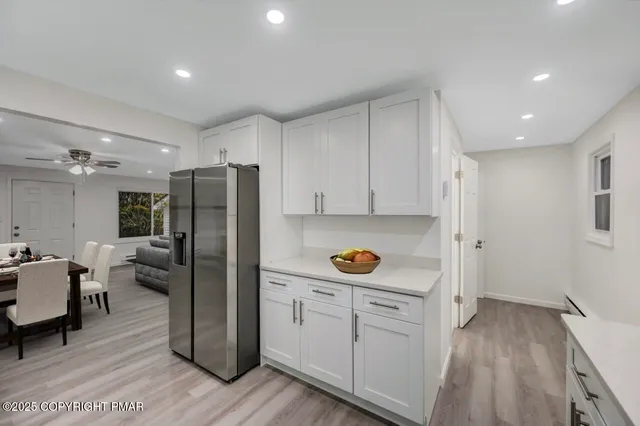 a living room with furniture and view of kitchen