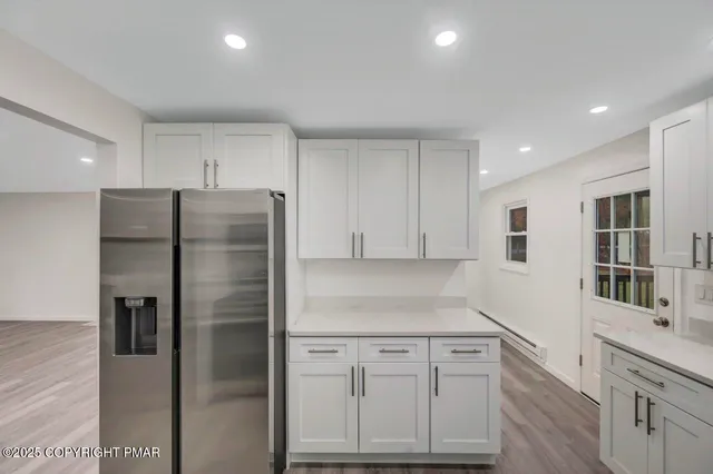 a view of an empty room with a window and wooden floor