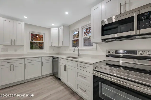 an empty room with wooden floor and ceiling fan