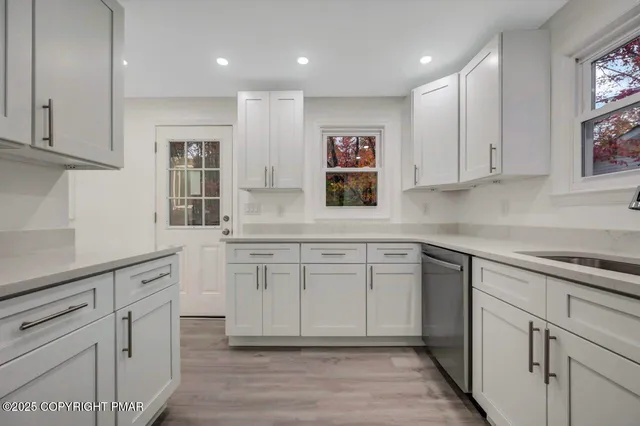 an empty room with wooden floor and a ceiling fan