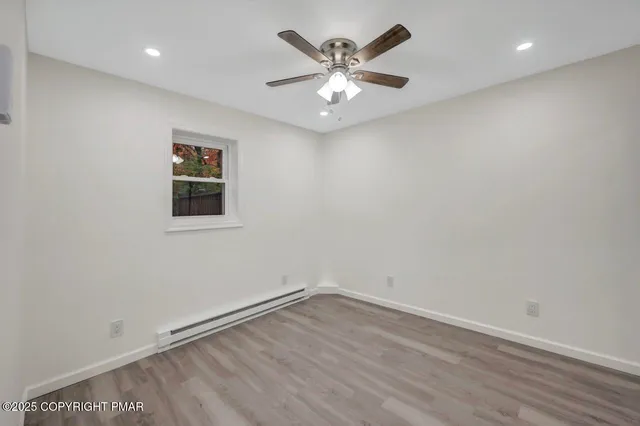 a view of backyard with wooden fence and large trees