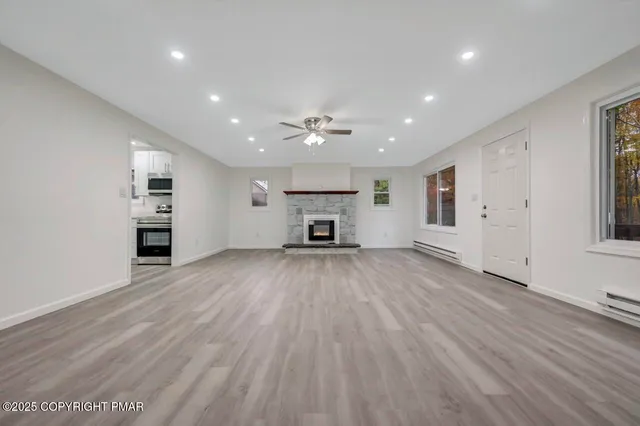a kitchen with a refrigerator a stove and white cabinets with wooden floor