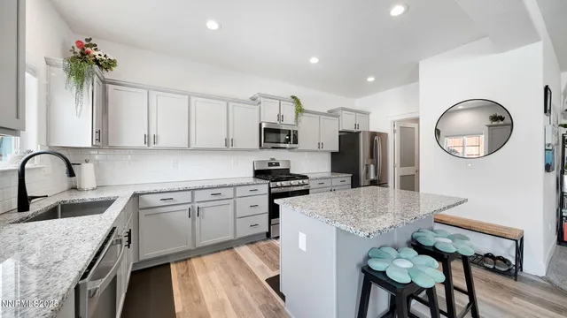 a kitchen with granite countertop a sink stainless steel appliances and cabinets