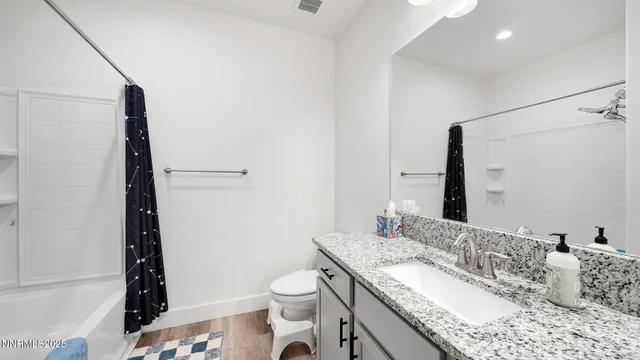 a bathroom with a granite countertop sink toilet and shower