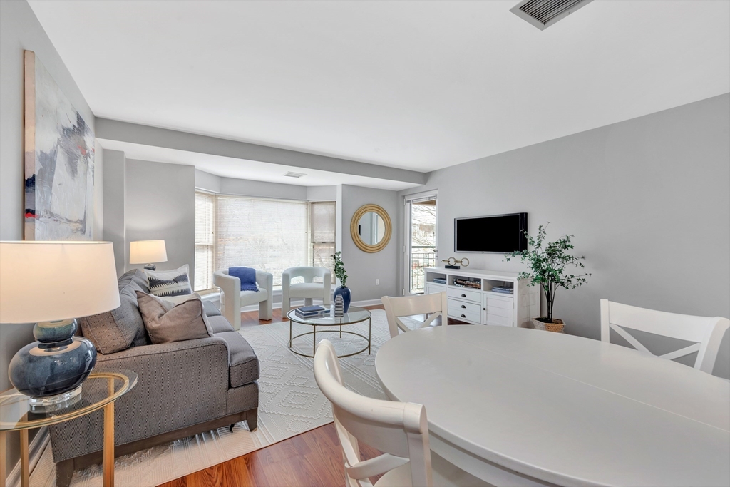 1 Watermill Place, Unit 312 Arlington, MA 02476 - Photo 11 of 33 a living room with furniture a flat screen tv and a window