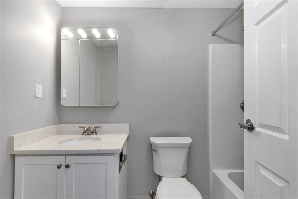 1 Watermill Place, Unit 312 Arlington, MA 02476 - Photo 18 of 33 a bathroom with a toilet sink and mirror