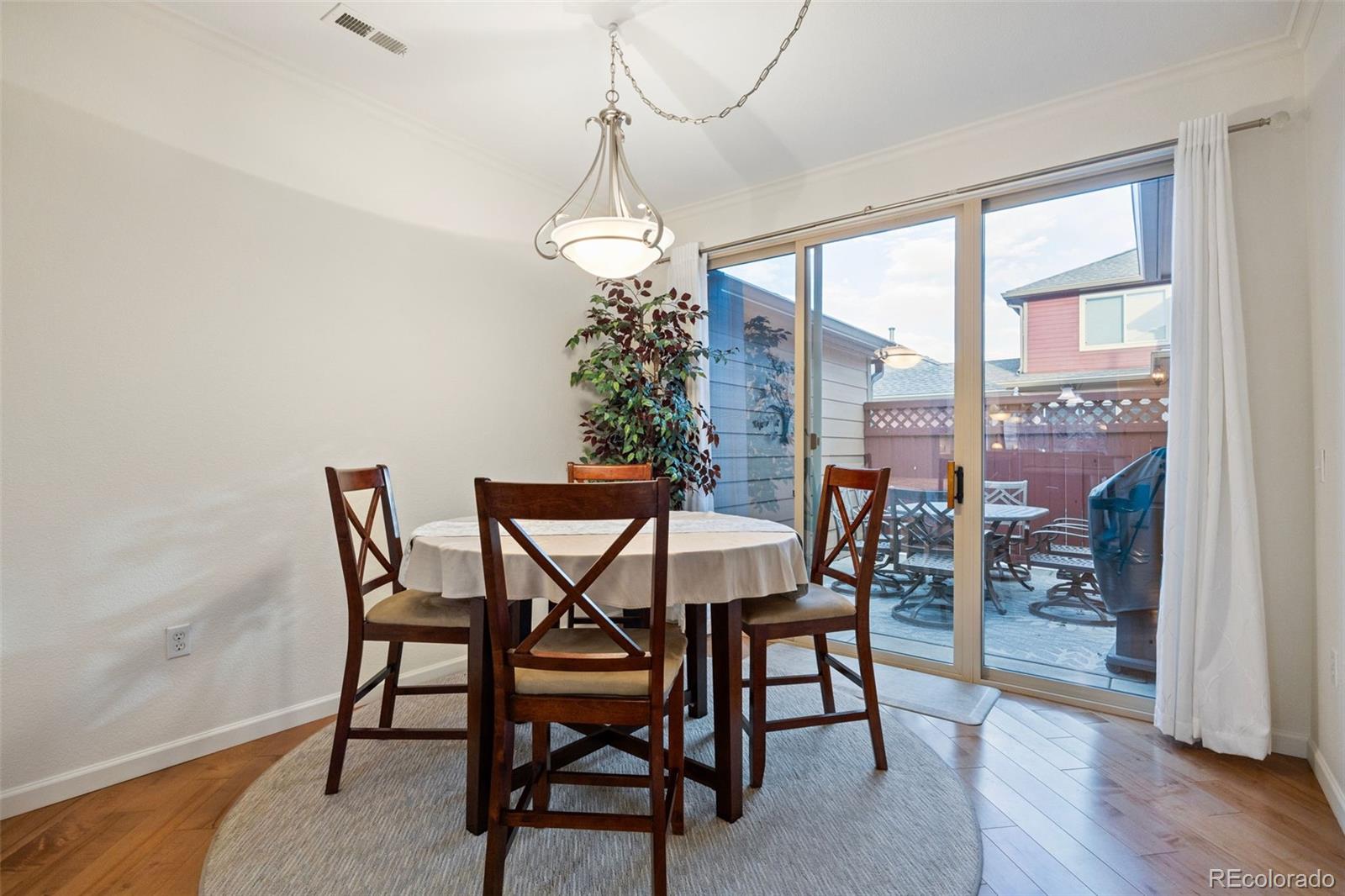 8558 Gold Peak Lane, Unit B Highlands Ranch, CO 80130 - Photo 11 of 41 a dining room with furniture a chandelier and wooden floor