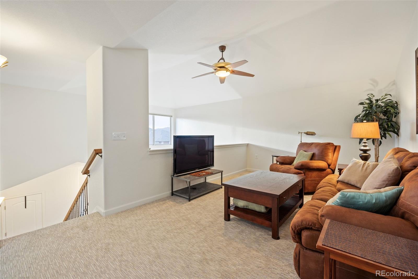 8558 Gold Peak Lane, Unit B Highlands Ranch, CO 80130 - Photo 23 of 41 a living room with furniture a ceiling fan and a rug
