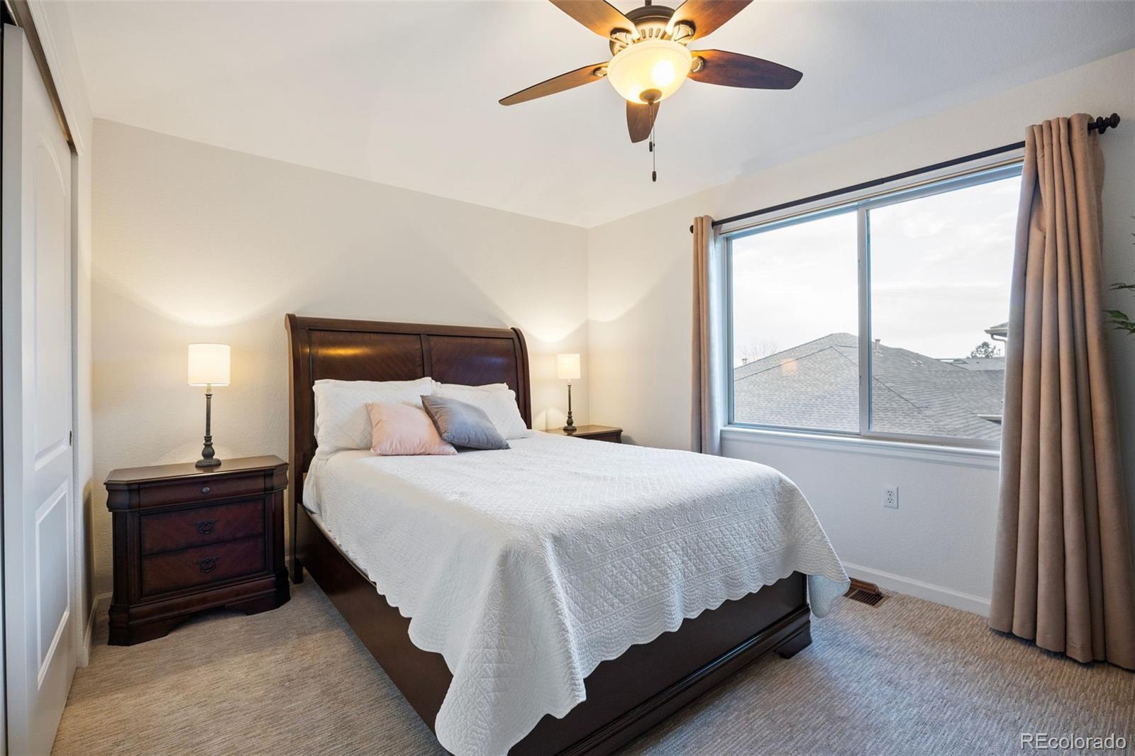 8558 Gold Peak Lane, Unit B Highlands Ranch, CO 80130 - Photo 24 of 41 a bedroom with a large bed and a large window