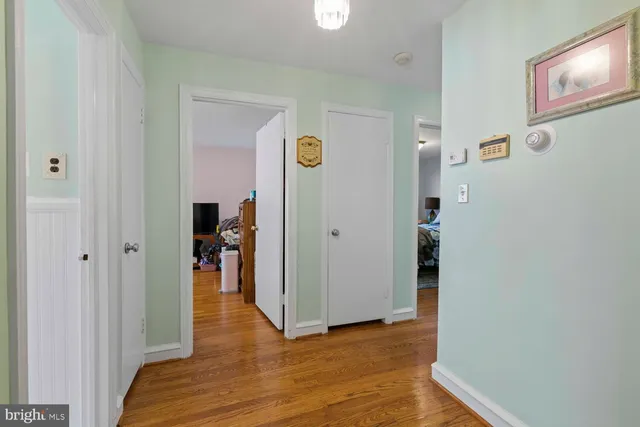 a view of a hallway with wooden floor and closet