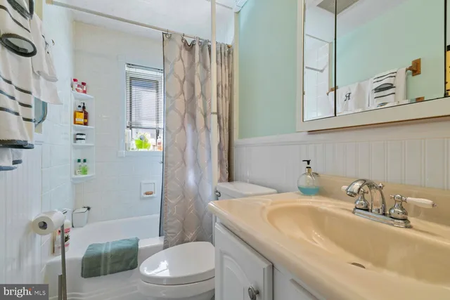 a bathroom with a granite countertop sink a toilet and shower
