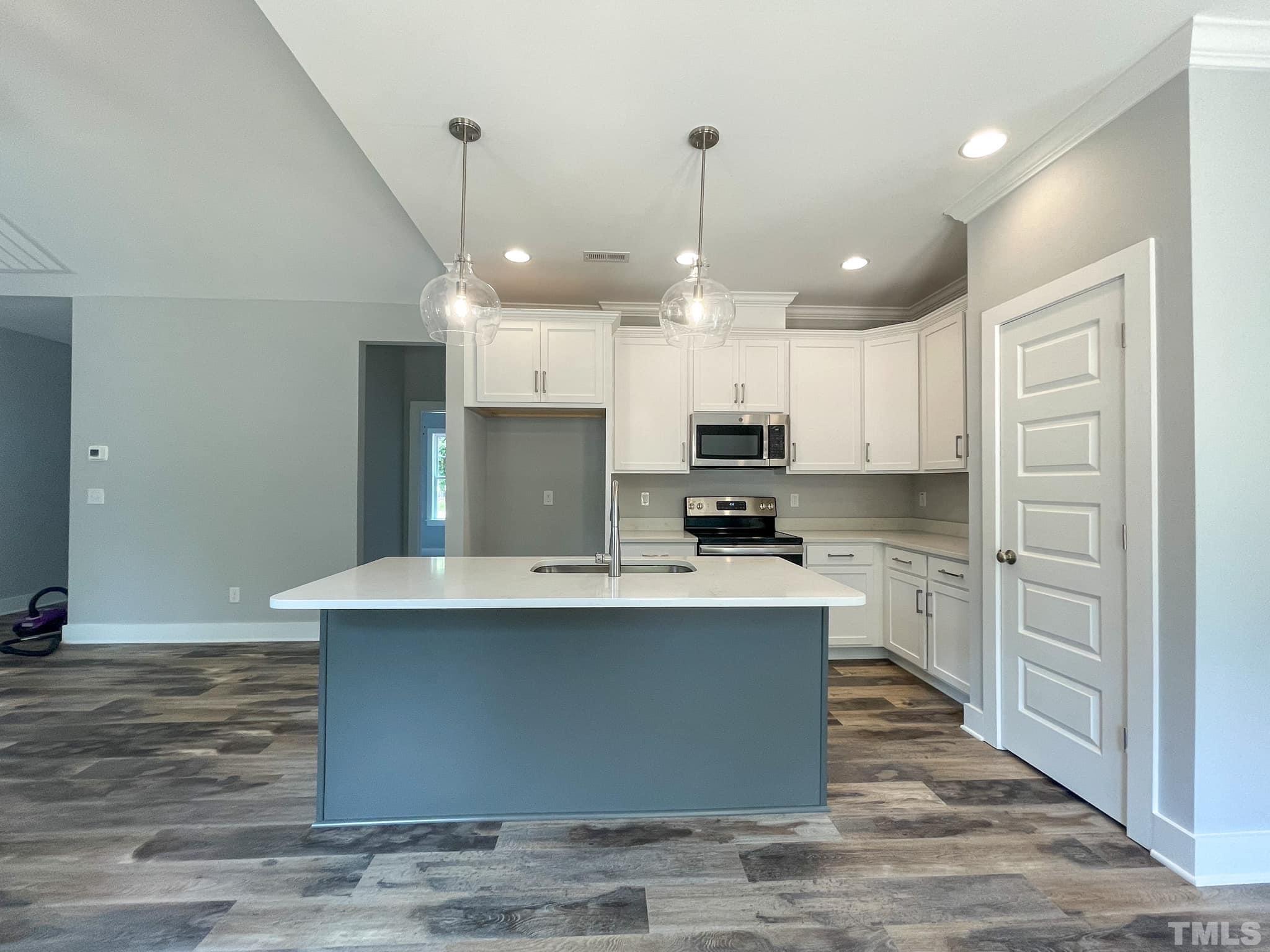 811 Ned Moore Road Timberlake, NC 27583 - Photo 5 of 33 a large kitchen with cabinets wooden floor and stainless steel appliances