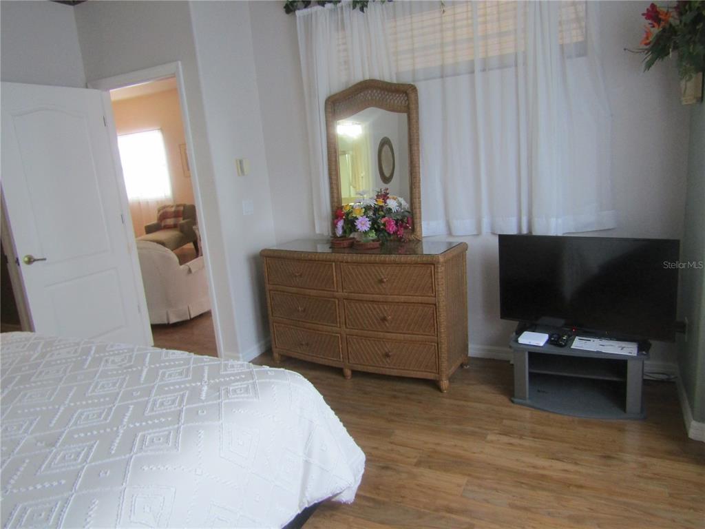4137 Bella Pasque Venice, FL 34293 - Photo 14 of 30 a bedroom with a bed and a flat tv screen on dresser