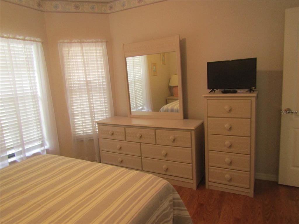 4137 Bella Pasque Venice, FL 34293 - Photo 19 of 30 a bedroom with a bed and a flat screen tv