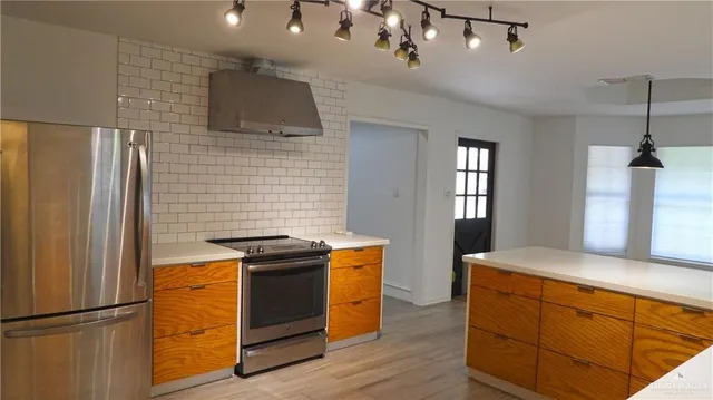 a kitchen with stainless steel appliances granite countertop a stove a refrigerator and a sink