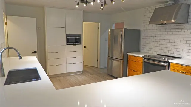 a kitchen with stainless steel appliances a refrigerator and a sink