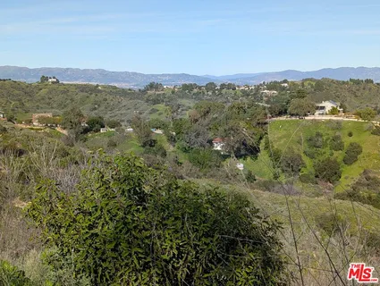 an aerial view of residential house with outdoor space and trees all around