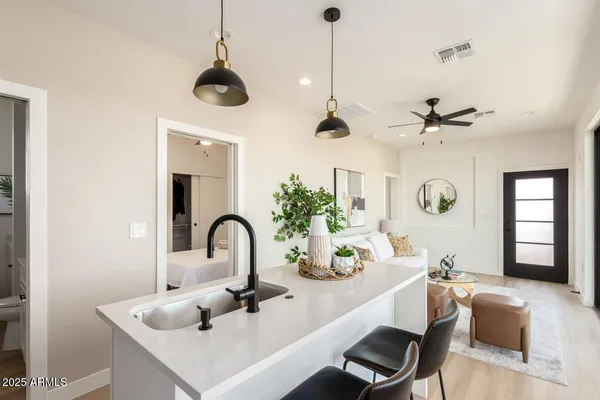a kitchen with a sink a counter and living room view