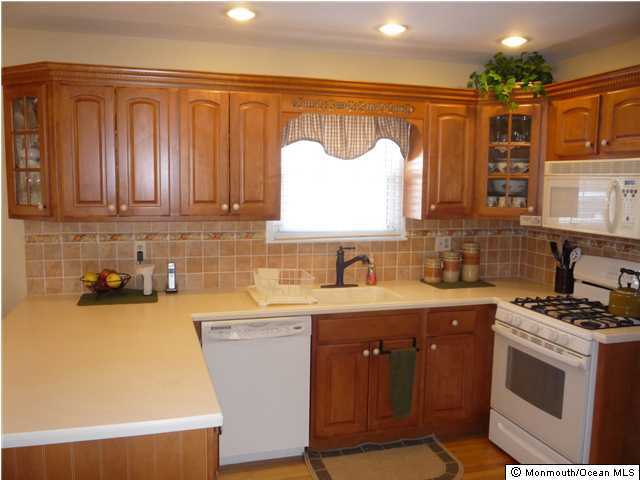 668 Thoroughfare Road Brick, NJ 08724 - Photo 2 of 3 a kitchen with a sink a stove cabinets and a window