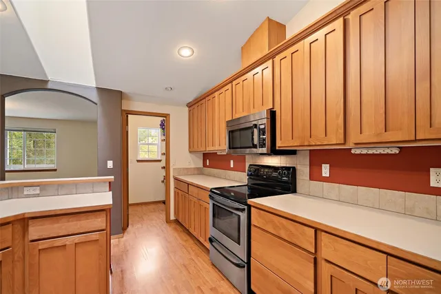 a kitchen with stainless steel appliances a stove microwave and cabinets