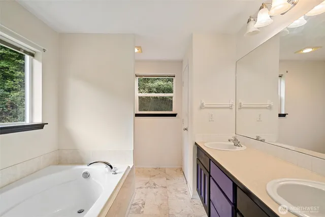 a bath room with a sink tub and a mirror