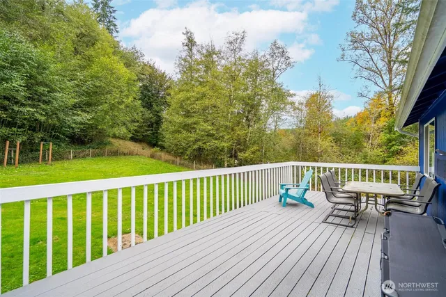 a view of deck with furniture and trees in the background