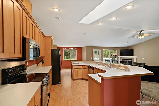 a kitchen with stainless steel appliances granite countertop a sink a stove and a refrigerator