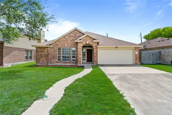 a front view of a house with a garden and yard