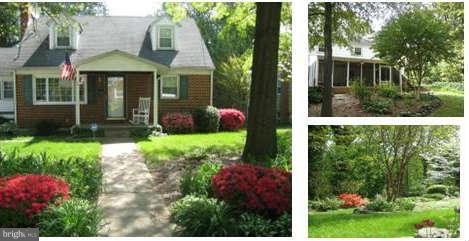 a view of a brick house with a yard and plants
