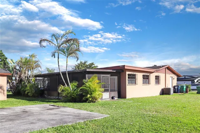 a front view of a house with a garden and trees