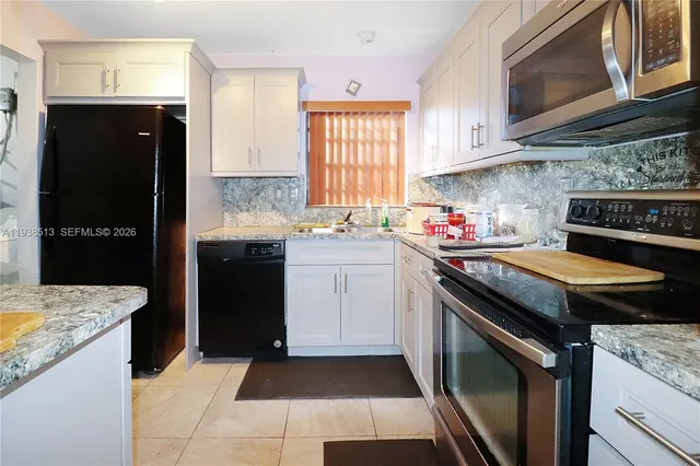 a kitchen with a stove sink and cabinets
