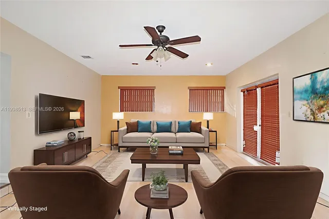 a living room with furniture a window and a flat screen tv