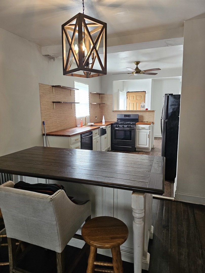 15354 5th Avenue Phoenix, IL 60426 - Photo 2 of 5 a kitchen with a table chairs refrigerator and window