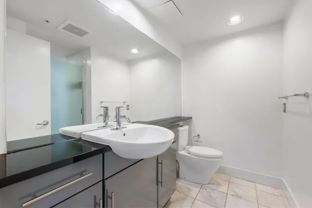 a bathroom with a vanity a sink a mirror and a shower