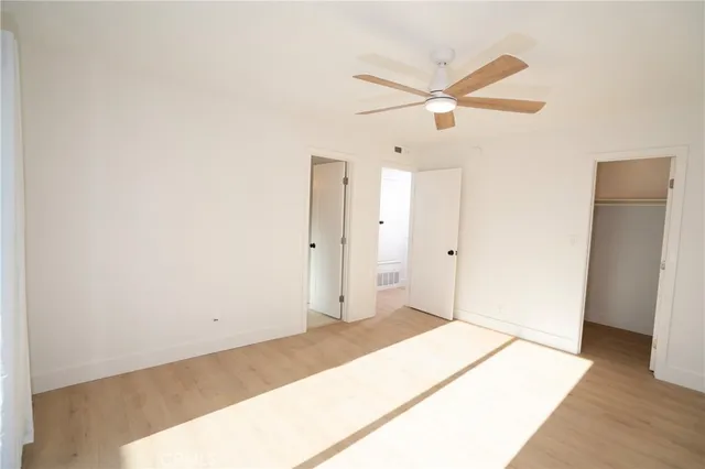 a bedroom with a bed and a ceiling fan