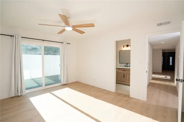 a view of a room with wooden floor and a ceiling fan