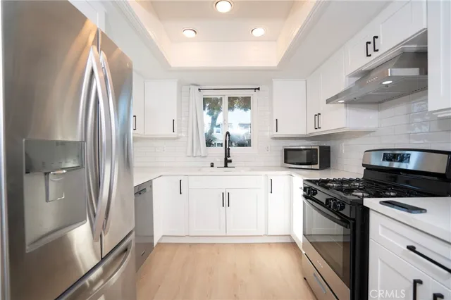 a kitchen with stainless steel appliances a sink stove and refrigerator