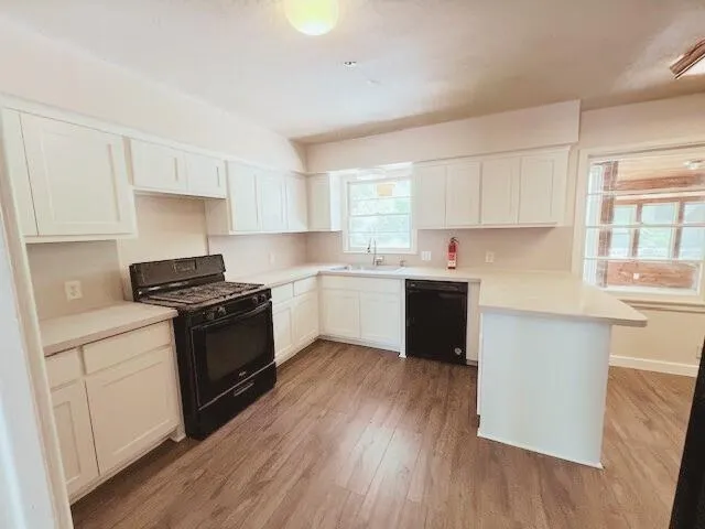 a kitchen with a sink a stove a counter space and a window
