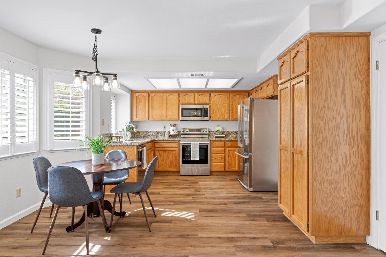 716 Hemmingway Court Tracy, CA 95376 - Photo 5 of 41 a kitchen with stainless steel appliances a microwave a stove a table and chairs